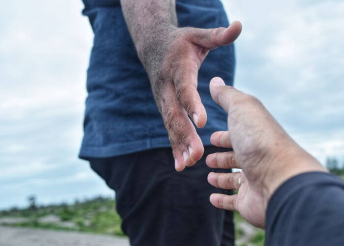 Outstretched hand reaching for another in a supportive way